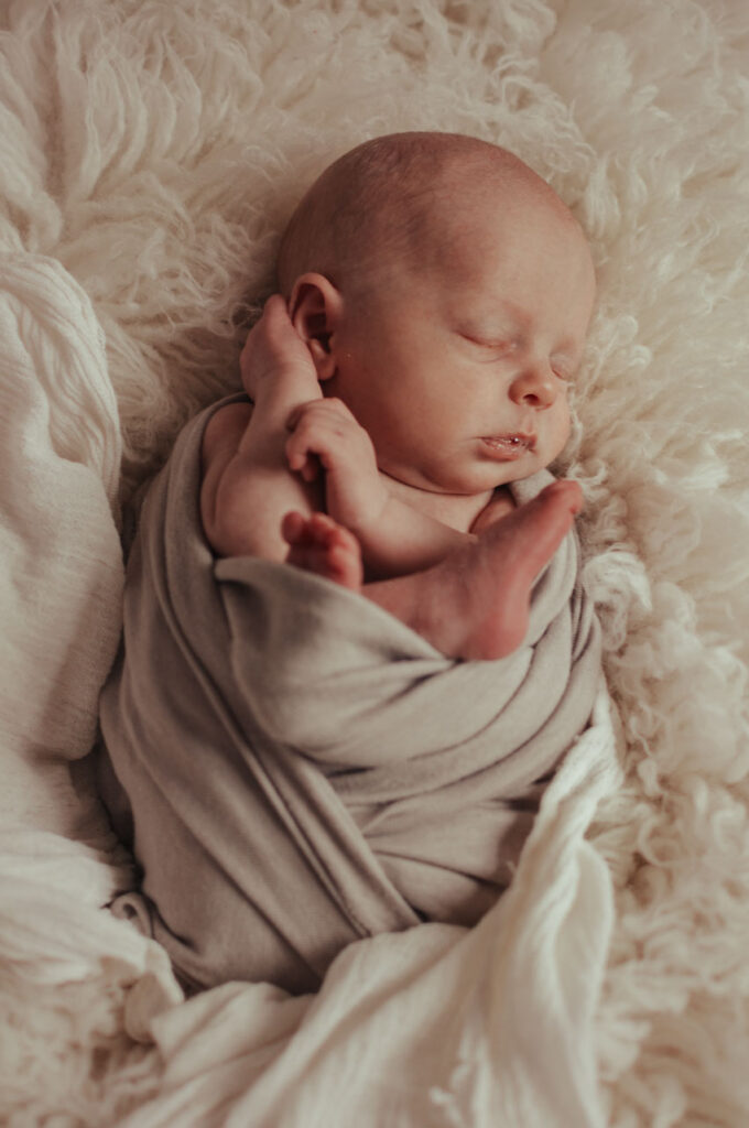 Newborn foto van piepjong kindje gewikkeld in laken
